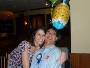 a photo of two siblings, male and female smiling together, with birthday decorations