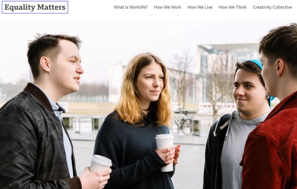 An image of 4 young adults huddled in conversation outside