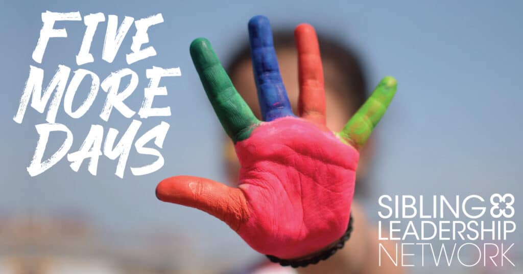 A colorfully painted had of a girl is held up showing all five fingers